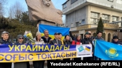 Собравшиеся в поддержку Украины активисты в Алматы развернули плакат с надписью «Пусть война в Украине прекратится». 24 февраля 2025 года