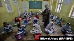 Students attend a class on the first day of primary school after the resumption of classes in Peshawar on September 30.