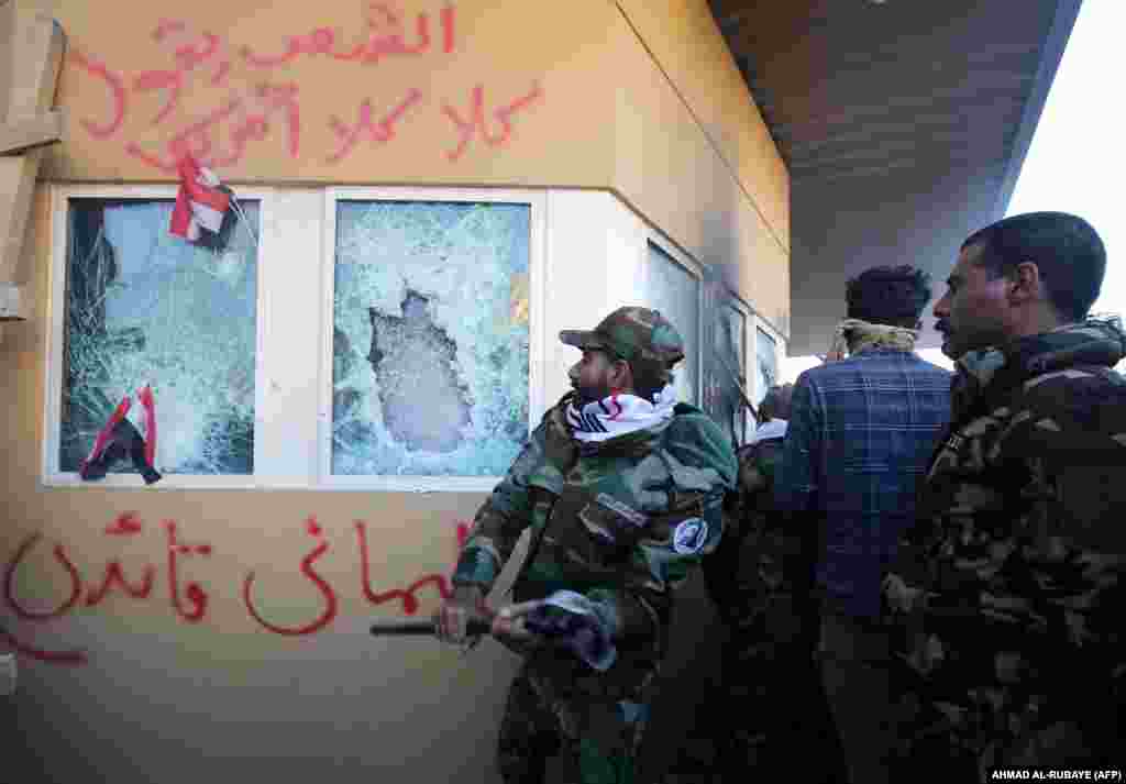 Members of an Iran-backed Shi'ite militia smash the bulletproof glass of the U.S. Embassy in Baghdad on December 31, 2019. The U.S. military said that Soleimani "approved the attack" and had organized several other attacks on U.S.-led coalition bases in Iraq over the past several months.