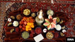 آرشیف- دسترخوانی که به مناسبت شب یلدا با میوه های تازه و خشک، شرینی و چراغ تزئین شده است.