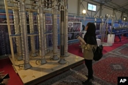Un student privește centrifugele construite în Iran într-o expoziție din Teheran, 8 februarie 2023.