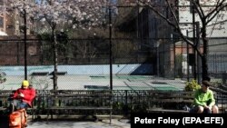 Люди дотримуються соціальної дистанції на території невеликого парку у Манхеттені, Нью-Йорк, США. 24 березня 2020 року