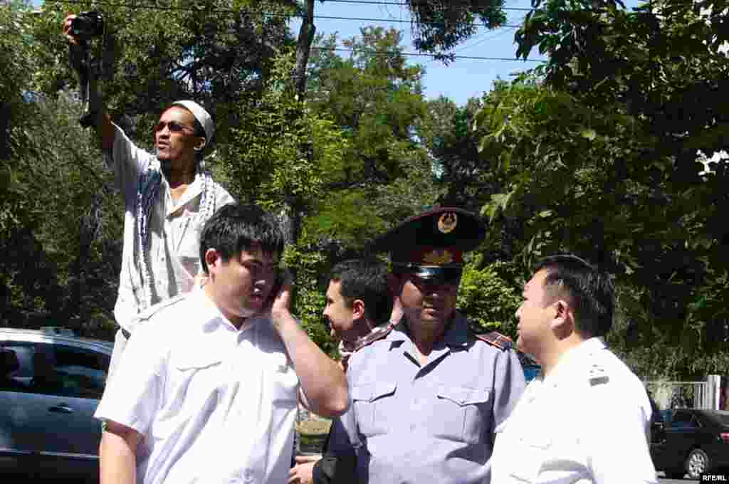 За ходом акции протеста наблюдали полицейские.  - Журналист фотографирует участников акции протеста в защиту СМИ. Рядом стоят прокурор и полицейские. Алматы, 24 июня 2009 года.