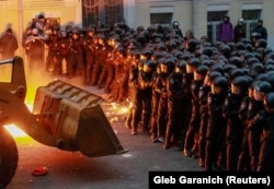 Шерушілер президент әкімшілігі ғимараты маңындағы полицияның қалың сабын бұзу үшін трактор қолданды. 1 желтоқсан 2013 жыл