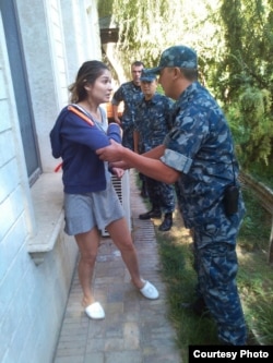 A photo that appeared in 2014 that apparently shows Gulnara Karimova being manhandled by security personnel while under house arrest.