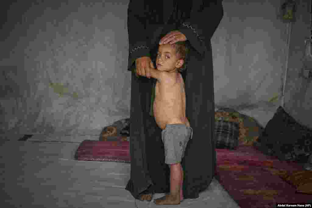 Mohammed Abu Hilal, 2-vjeçar, pranë nënës së tij, Yasmine, brenda tendës së tyre në kampin Muvasi për palestinezët e zhvendosur, në Han Junis, jugu i Rripit të Gazës, më 18 maj 2025.