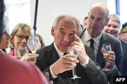 „Decât să-l dăm cu tarif majorat...” Premierul francez Francois Bayrou și ministrul economiei Eric Lombard gustă un pahar la „Maisons des Vins d'Anjou et de Saumur", în vestul Franței, la 24 iulie.