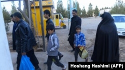 An Afghan family arrives with their belongings at an International Organization for Migration transit center in Herat after arriving from Iran last year.