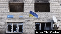 Steagul Ucrainei pe o clădire avariată de bombardamente în Siversk, 20 februarie 2023