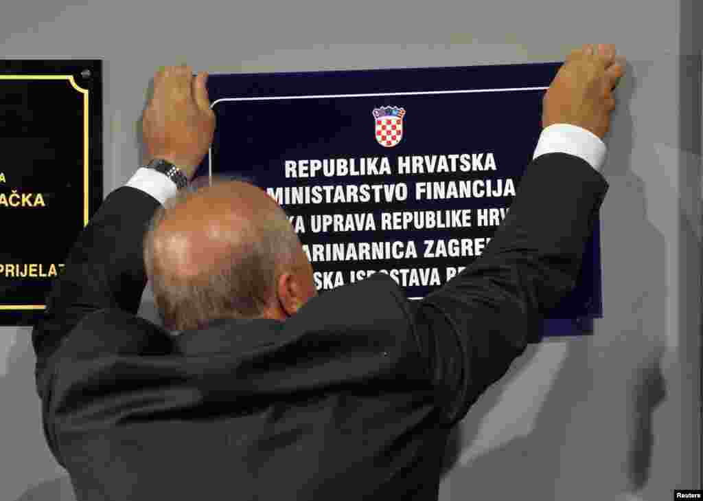 Hrvatski Ministar finansija Slavko Linić skida tablu carinske postaje na graničnom prelazu Bregana