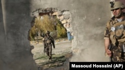 Afghan soldiers near a hole in a wall made to rescue people from the Shamshad TV building after a deadly attack in Kabul on November 7.