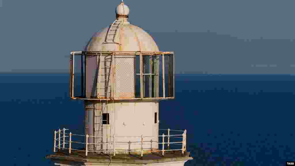 Однак містичну атмосферу порушує (а, можливо, і навпаки &ndash; підтримує) меганомський маяк. Розташований на самому краю мису, він вказував шлях кораблям з 1895 року. Біла кам'яна башта маяка з'явилася тут за наказом царя Олександра II, який підписав у 1875 році &laquo;План споруди і переобладнання берегових і плавучих маяків та портових вогнів на морях Росії&raquo;