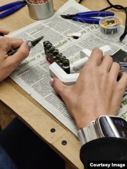 ლვოვში მდებარე სახელოსნოში ქალი ლიდსიდან გამოგზავნილ ვეიპების ბატარეებს აწყობს ენერგობლოკისთვის.