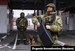 Një ushtar bjellorus qëndron me një pajisje anti-dron në një pikë kalimi kufitar, në kufirin me Ukrainën.