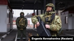 Un soldat belarus cu dispozitiv anti-dronă la un punct de trecere a frontierei, la granița cu Ucraina.