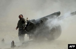 An Afghan National Army soldier fires an artillery shell during clashes between Afghan security forces and IS militants in Nangarhar in September.