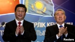 Kazakh President Nursultan Nazarbaev (right) and his Chinese counterpart Xi Jinping applaud after a gas pipeline launch.