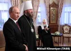 Президент Росії Володимир Путін (ліворуч) під час вручення державної нагороди Росії керуючому справами Української православної церкви (Московського патріархату), митрополиту Антонію (Івану Паканичу). Праворуч – патріарх Московський Кирило. Київ, 27 липня 2013 року