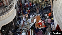 Rescue workers gather at the site of a passenger plane crash in a residential area near an airport in Karachi on May 22.