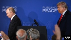 Președintele SUA, Donald Trump (dreapta), și președintele rus, Vladimir Putin, pleacă de pe podium după summitul din Alaska, pe 15 august.