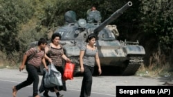 იგოეთი. დევნილები ცდილობენ დასახლების დატოვებას. 2008 წლის აგვისტო 
