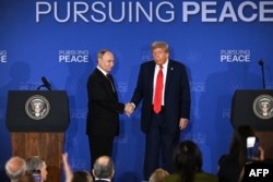 Președintele SUA, Donald Trump (dreapta), și președintele rus, Vladimir Putin, îți strâng mâinile la finalul conferinței de presă comune, după summitul privind Ucraina, la baza militară Elmendorf-Richardson din Anchorage, Alaska, pe 15 august 2025.