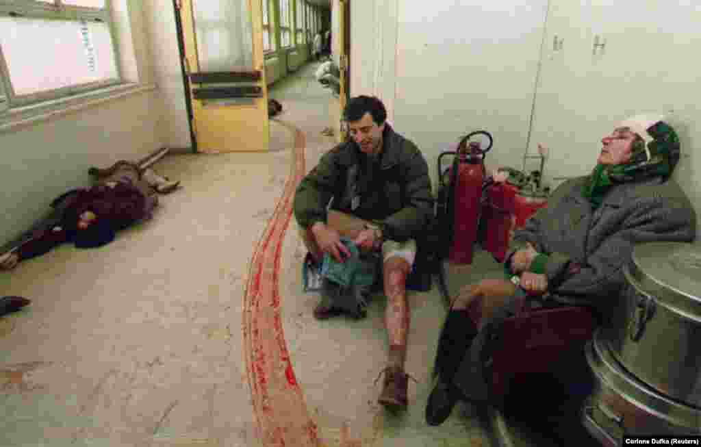 Civilians injured by a mortar in Sarajevo's central market await treatment in a hospital corridor on February 5, 1994. The woman at left died before doctors could attend to her.