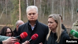 Lithuanian President Gitanas Nauseda (left) speaks to the media next to U.S. Ambassador to Lithuania Kara C. McDonald at the site of a rescue operation at the Pabrade training ground.