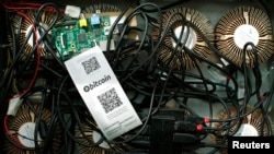 Na platformama za rudarenje kriptovaluta programeri su tvrdili da bi investitori mogli „kupiti bitkoin po upola nižoj tržišnoj ceni“ zbog „24-7 rudarstva“ u objektima „širom sveta“ (na fotografiji mašina za bitkoin rudarenje)