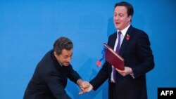 საფრანგეთის პრეზიდენტი ნიკოლა სარკოზი და ბრიტანეთის პრემიერ-მინისტრი დევიდ კამერონი ხელშეკრულების გაფორმების დროს