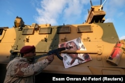 ხალიფა ჰაფთარის ლიბიის ეროვნული არმიის მეომარი ავტომატს უმიზნებს რეჯეპ ერდოანის პორტრეტს თავისი ჯავშანტრანსპორტიორიდან. ქალაქი სირტი. 2020 წლის ივლისი.