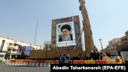 یک موشک بالستیک در کنار تصویری از علی خامنه‌ای در یک نمایشگاه خیابانی در تهران، مهرماه ۱۳۹۸