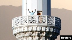 Мулла читает молитву азан с минарета мечети в Ашгабате. 19 августа 2007 года.