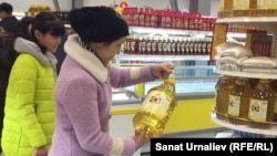 Өсімдік майын таңдап тұрған тұтынушы. Көрнекі сурет.