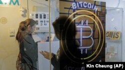 Prolaznici koriste bankomat za bitcoin u Hong Kongu