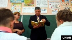 Тодішній міністерський комісар з питань управління транскордонними інвестиціями Управління прем'єр-міністра Угорщини Іштван Ґрежа розглядає підручник з угорської мови під час візиту на Закарпаття, в одному з класів початкової школи з поглибленим вивченням угорської мови. Закарпатська область, Свалява, 5 листопада 2015 року