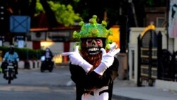 India: un polițist în trafic, în Bangalore, poartă o cască în formă de coronavirus, în efortul de a convinge oamenii să rămână acasă. Prim-ministrul indian Narendra Modi a dispus restricții pe parcursul a 21 de zile, începând cu miezul nopții de 24 martie, pentru a stopa răspândirea coronavirusului.