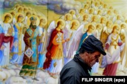 Полициядан қорғанған шерушілердің кейбірі сол маңдағы шіркеуге тығылды. Мына суретте жараланған азаматтардың бірі шіркеу маңынан өтіп барады. 30 қараша 2013 жыл