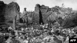 A 1915 photo purportedly shows soldiers standing over the skulls of victims from the Armenian village of Sheyxalan in the Mush Valley, on the Caucasus front during World War I.