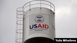 Turn de apă la Porumbeni, finanțat prin USAID. Asemenea inscripții se găsesc cu zecile în R. Moldova.