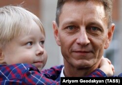 Liberal Democratic Party candidate Vladimir Sipyagin poses with his son after voting in the Vladimir region runoff he later won on September 23.