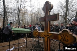 Mourners attend a funeral to bury two teenagers who were killed by shelling on November 5.