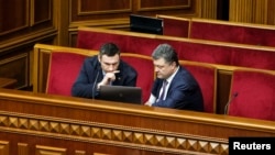 Vitali Klitschko (left) and Petro Poroshenko, confectionery billionaire and presidential candidate, look at a laptop computer in the pews of parliament in early April.
