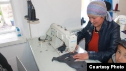 Кийим тигип отурган келин.