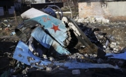 Fragmente ale unui avion de vânătoare rusesc Su-34 pe o casă din Cernigău, Ucraina, 6 aprilie 2022.