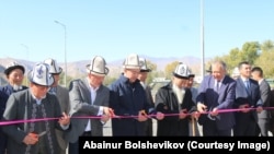 Кубатбек Боронов и Улан Примов перерезают красную ленту в присутствии местных жителей. 15 октября 2019 г.
