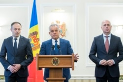 Kryetari i Partisë Demokratike, Vladimir Plahotniuc (në mes), Andrian Candu (majtas) dhe Pavel Filip në një konferencë për media.