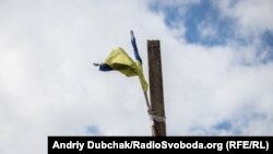 Український прапор на стовбі біля магазину у центрі Золотого-4