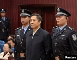 Кытай компартиясынын өмүр бою эркинен ажыратылган көрүнүктүү ишмери Бо Силай (ортодо) сот залында. 25-октябрь 2013