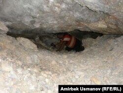 Мурдакы кенчи Тургун Муратов сымап казылчу эски кендин төрүндөгү тешиктердин бирине сойлоп кирип баратат. Сарт-Ыстаган. 20-июль ,2011